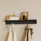 Schwarze Garderobe Commeo montiert an der Wand besetzt mit einer Jacke, einem Beutel, Post und einem Bilderrahmen aus Holz.