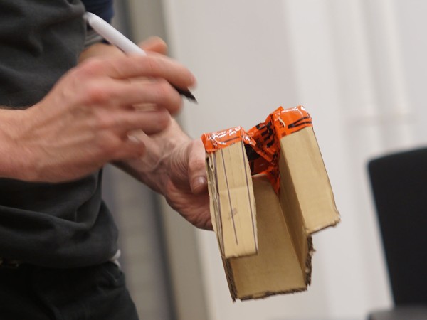 Person h&auml;lt einen aufgeschnittenen Versandkarton aus Recyclingpappe in der Hand